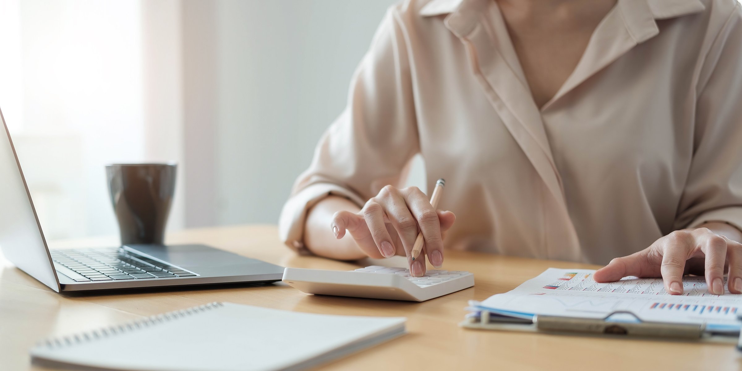 Business Woman Working in Finance and Accounting Analyze Financial Budget with Calculator and Laptop Computer in the Office